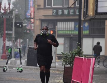 A Portland, Ore., resident wears a respirator to protect himself from wildfire smoke as he jogs