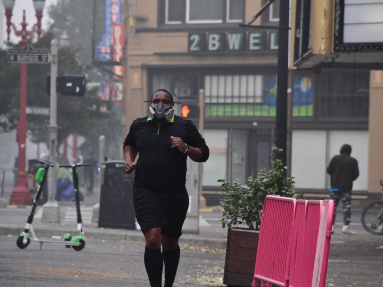 A Portland, Ore., resident wears a respirator to protect himself from wildfire smoke as he jogs