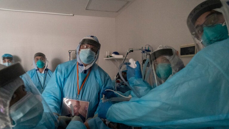 Health care workers in Houston, Texas, perform a procedure on a patient in the COVID-19 intensive care unit
