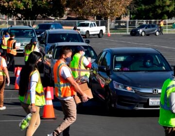 Food is loaded as drivers in their vehicles wait in line at a food distribution hosted by the Los Angeles Food Bank on Dec. 4 in Hacienda Heights, Calif. (Frederic J. Brown/AFP via Getty Images)