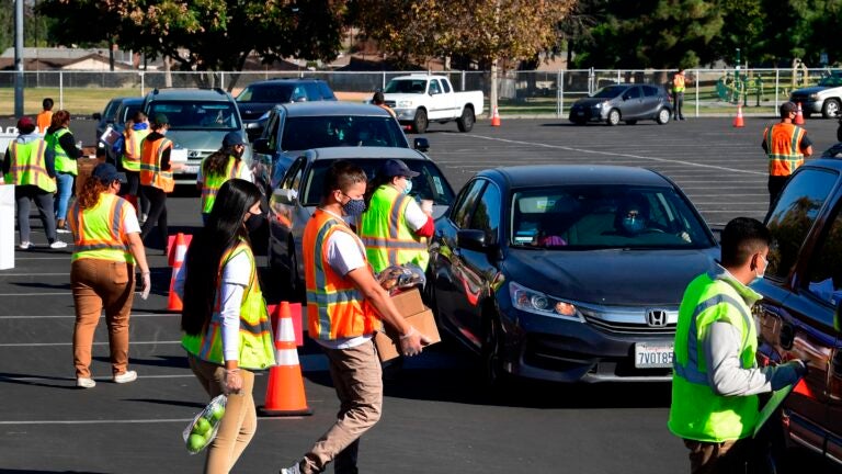 Food is loaded as drivers in their vehicles wait in line at a food distribution hosted by the Los Angeles Food Bank on Dec. 4 in Hacienda Heights, Calif. (Frederic J. Brown/AFP via Getty Images)