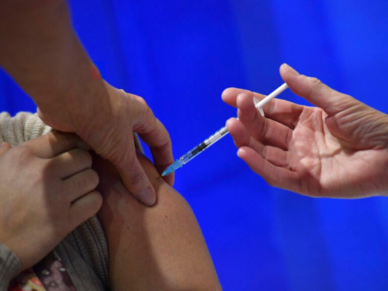 A woman receives an injection of the Pfizer-BioNTech Covid-19 vaccine at a health centre on the first day of the largest immunisation programme in the UK's history on December 8, 2020 in Cardiff, United Kingdom.