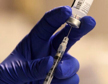 A pharmacist fills a syringe to prepare a dose of the Pfizer-BioNTech vaccine for front-line health care workers in Torrance, Calif., Saturday.