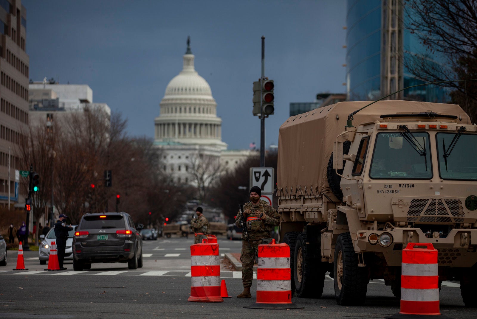 A military vehicle and orange traffic cones are pictured in front of the U.S. Capitol