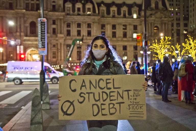 A protester holds up a sign that says ''Cancel Student Debt''