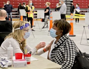 Registered nurse Pat DeHorsey vaccinates Cornelia Lavong at a county run clinic