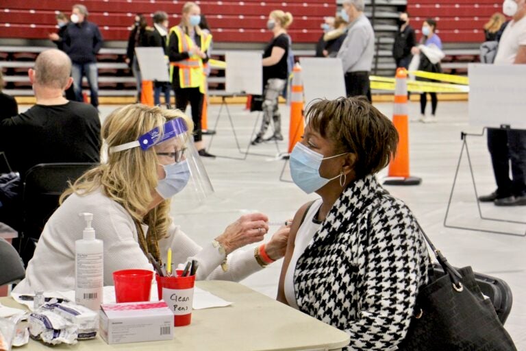 Registered nurse Pat DeHorsey vaccinates Cornelia Lavong at a county run clinic