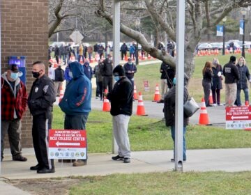 Hundreds of people line up outside to be vaccinated against COVID-19.