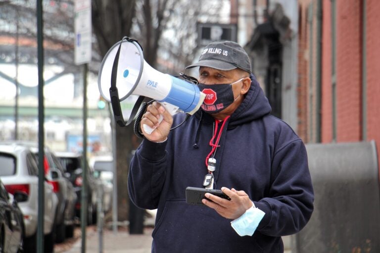 Jamal Johnson uses a megaphone at 3rd and Race streets outside the home of Mayor Jim Kenney