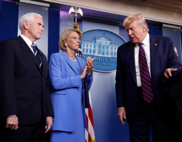 President Donald Trump leaves the podium after a briefing in the James Brady Press Briefing Room, Friday, March 27, 2020, in Washington, as Vice President Mike Pence and Education Secretary Betsy DeVos watch, (AP Photo/Alex Brandon)