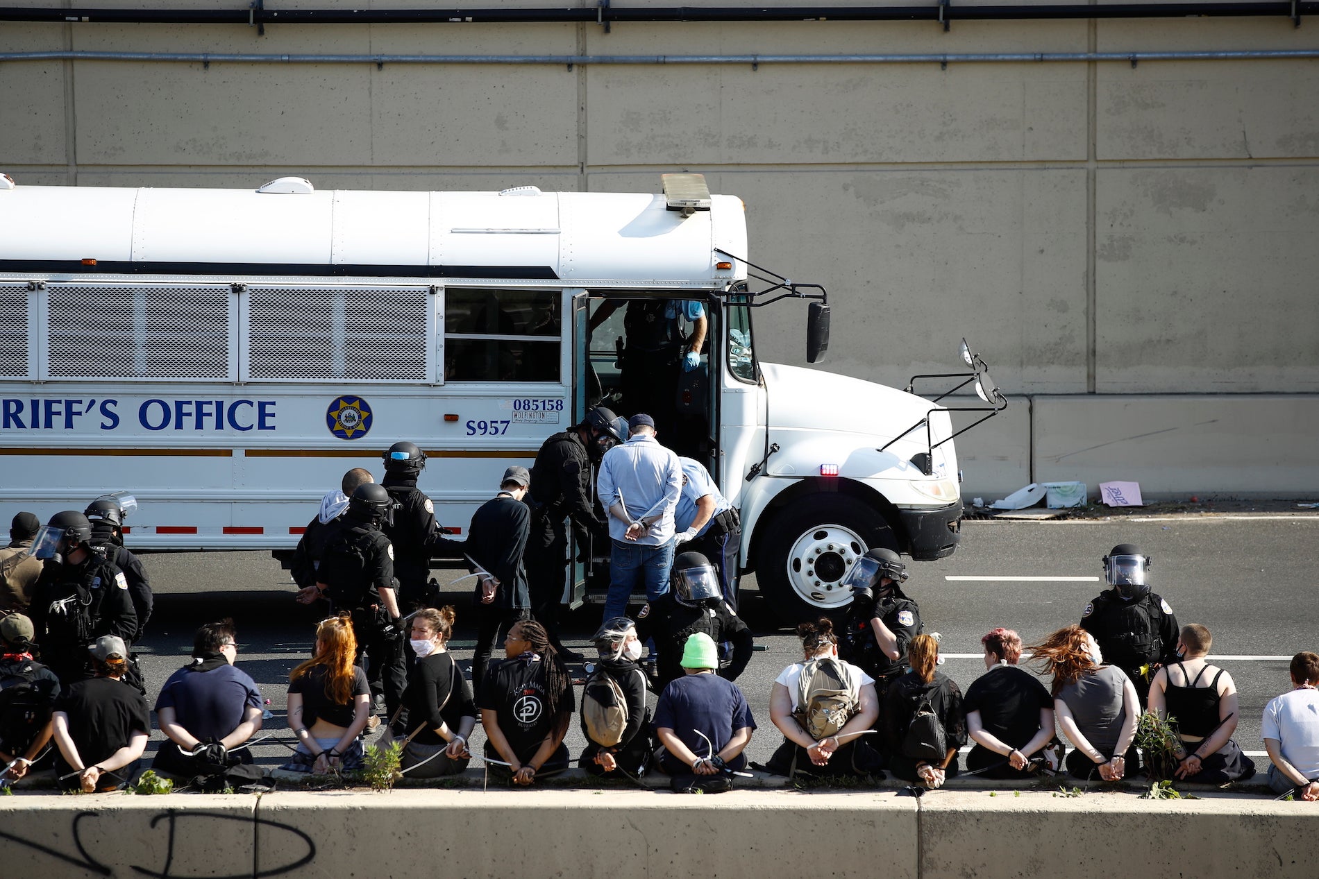 A police officer detains a climate activist after she sprayed