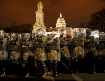 District of Columbia National Guard stand outside the Capitol, Wednesday night, Jan. 6, 2021, after a day of rioting protesters. It's been a stunning day as a number of lawmakers and then the mob of protesters tried to overturn America's presidential election, undercut the nation's democracy and keep Democrat Joe Biden from replacing Trump in the White House. (AP Photo/John Minchillo)