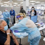 Sergeant Brian Patrick McKnerney, of the New Jersey State Police, receives a COVID-19 vaccination at the Morris County, vaccination site, in Rockaway, NJ, Friday, Jan. 8, 2021. (Sarah Blesener/The New York Times via AP, Pool)