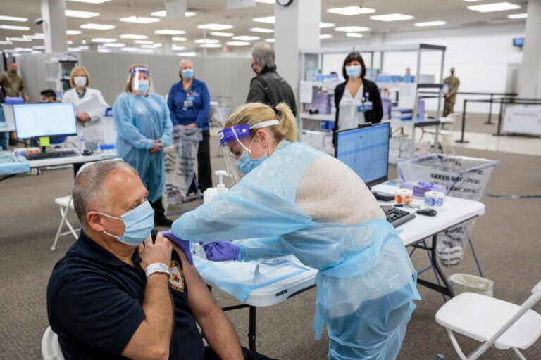 Sergeant Brian Patrick McKnerney, of the New Jersey State Police, receives a COVID-19 vaccination at the Morris County, vaccination site, in Rockaway, NJ, Friday, Jan. 8, 2021. (Sarah Blesener/The New York Times via AP, Pool)