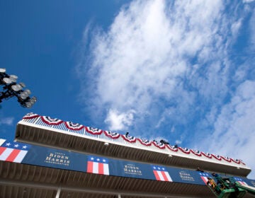 Workers install a banner on a platform near the White House as preparations are made for President-elect Joe Biden's inauguration ceremony, Monday, Jan. 18, 2021, in Washington. (AP Photo/Jose Luis Magana)