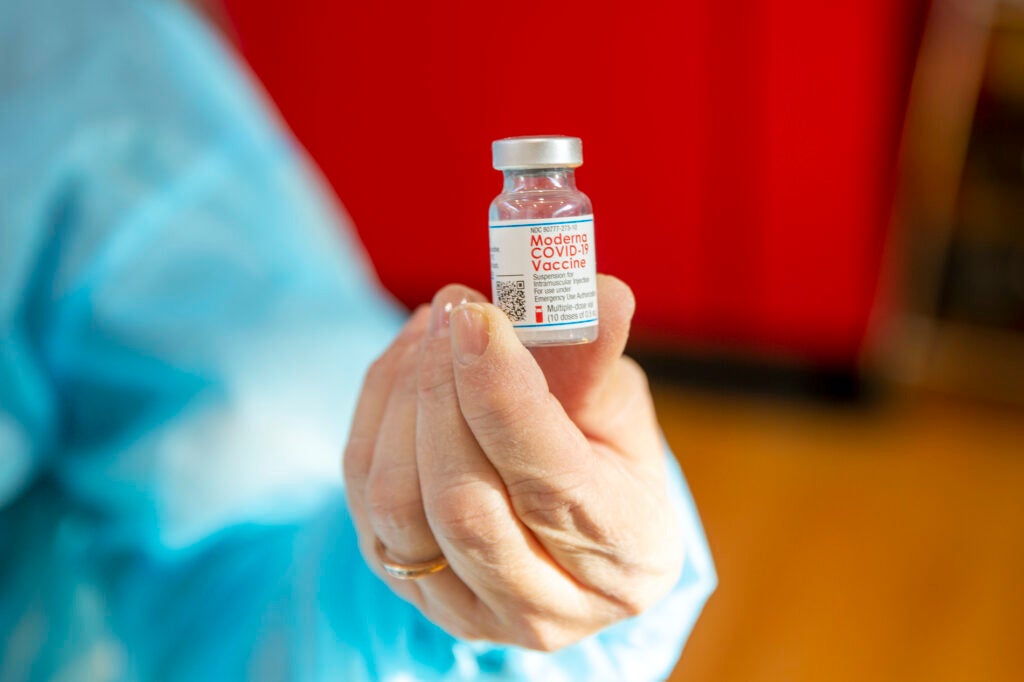 Woman holds vial of Moderna COVID-19 vaccine 