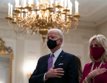 President Joe Biden, accompanied by first lady Jill Biden, places his hand over his heart during a performance of the national anthem, during a virtual Presidential Inaugural Prayer Service in the State Dinning Room of the White House, Thursday, Jan. 21, 2021, in Washington. (AP Photo/Alex Brandon)