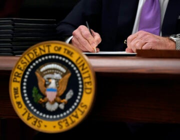 President Joe Biden signs executive orders after speaking about the coronavirus in the State Dinning Room of the White House, Thursday, Jan. 21, 2021, in Washington. (AP Photo/Alex Brandon)