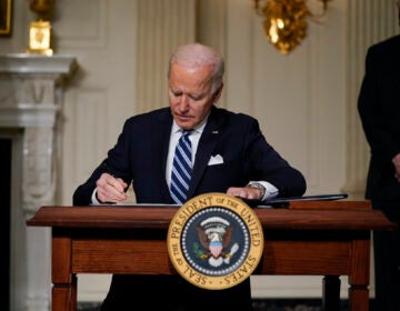 President Joe Biden signs an executive order in the State Dining Room of the White House. (AP Photo/Evan Vucci)