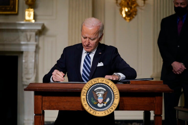 President Joe Biden signs an executive order in the State Dining Room of the White House. (AP Photo/Evan Vucci)