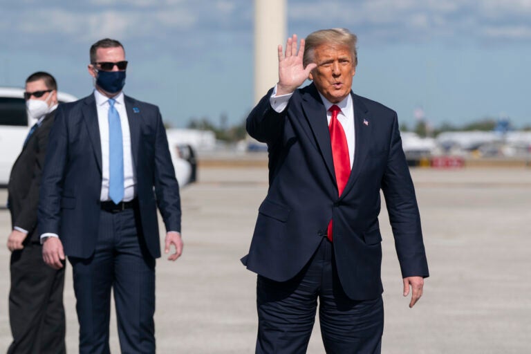 Former President Donald Trump waves to the members of the media