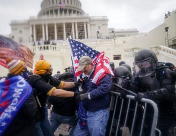 Pro-Trump rioters try to break through a police barrier at the Capitol