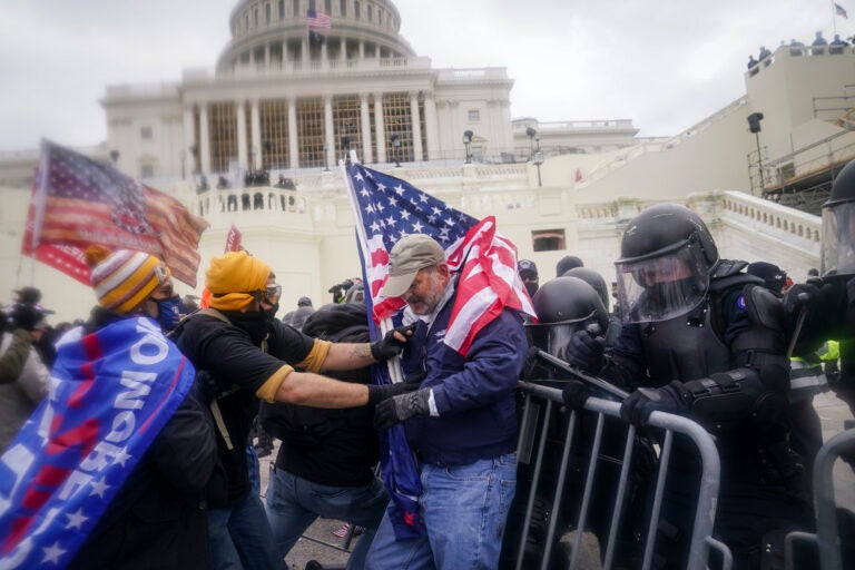 Pro-Trump rioters try to break through a police barrier at the Capitol