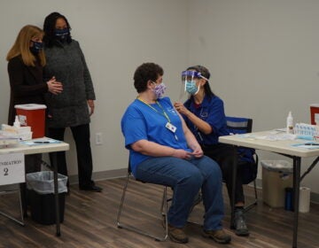 Amy Zoll, a volunteer with the Citizen Corps of Delaware County, becomes the first person to be vaccinated at the ribbon cutting for the new Delaware County Wellness Center. (Kenny Cooper/WHYY)