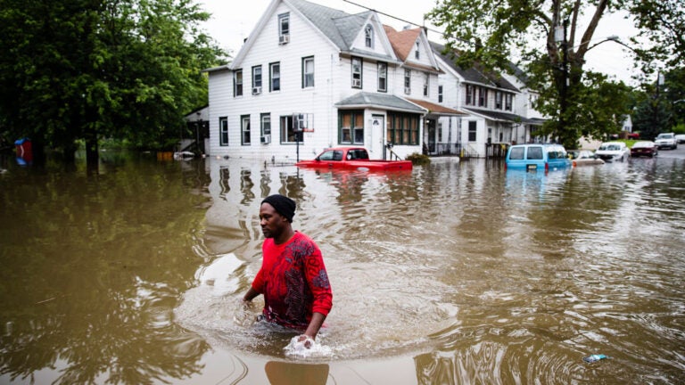 In this June 20, 2019 file photo, Chris Smith makes his way through floodwaters in Westville after severe storms swept across southern New Jersey. (AP Photo/Matt Rourke)