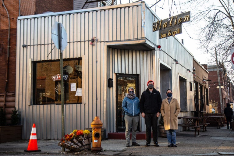 Neighbors Allison Sacks (left), Brayden Varr (center) and Christie Vazquez (right) outside the Station Bar at 16th and McKean streets in South Philadelphia. (Kimberly Paynter/WHYY)