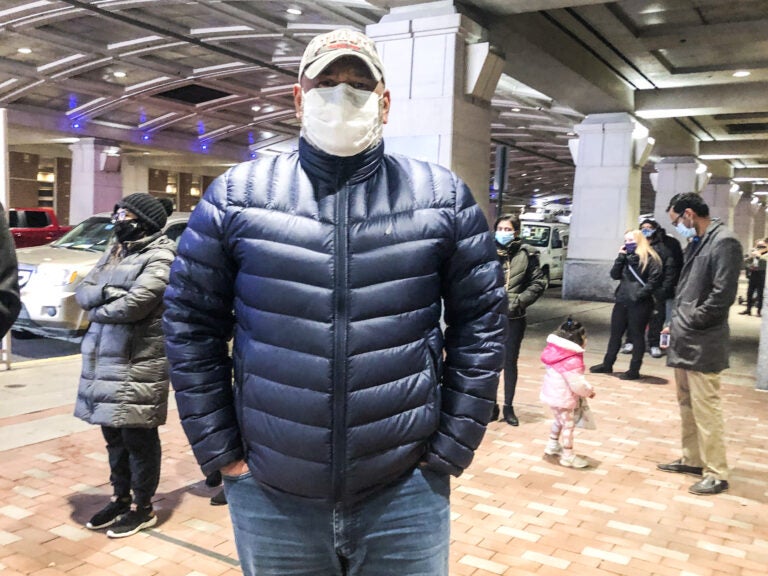 Julio Polanco, a behavioral care specialist at Children’s Crisis Treatment Center, stands in line at Philadelphia’s community vaccination clinic at the Pennsylvania Convention Center. (Nina Feldman/WHYY)