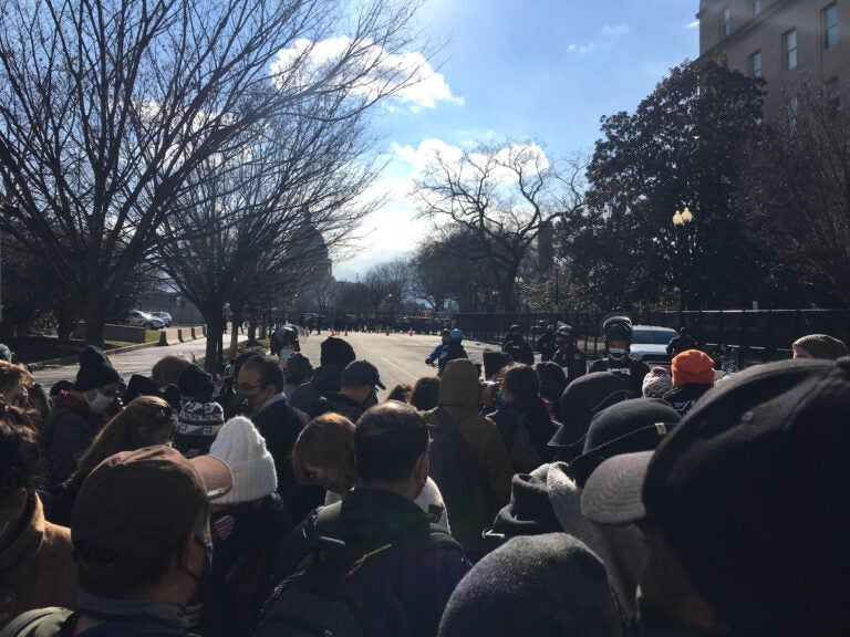 A crowd of about 50 presses towards the security barrier in an unsuccessful attempt to hear parts of the inauguration program. (Mark Eichmann/WHYY News)