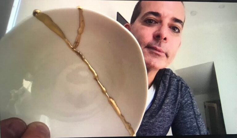 Dr. Matthew Beshara holds up a piece of pottery