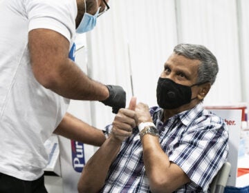 A person gives the thumbs up sign after receiving a dose of the Covid-19 vaccination at the New Jersey Convention and Exposition Center in Edison, New Jersey, U.S., on Friday, Jan. 15, 2021. New Jersey will expand Covid-19 vaccinations to people 65 years old and over and those ages 16 to 64 who have 