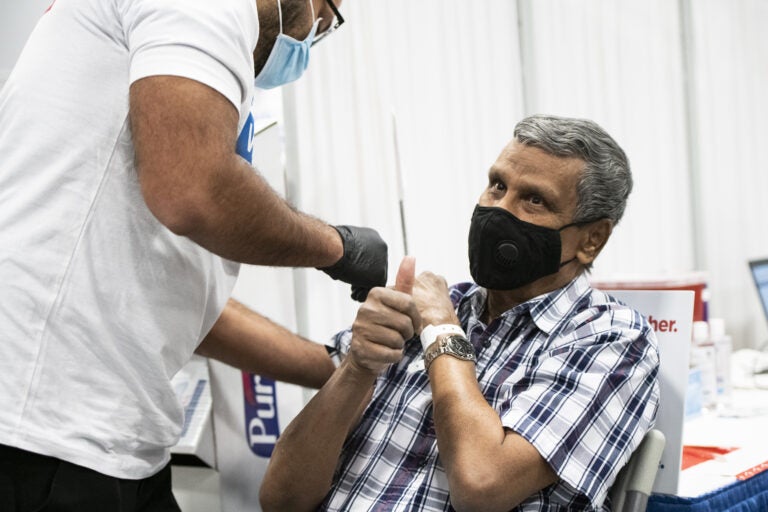 A person gives the thumbs up sign after receiving a dose of the Covid-19 vaccination at the New Jersey Convention and Exposition Center in Edison, New Jersey, U.S., on Friday, Jan. 15, 2021. New Jersey will expand Covid-19 vaccinations to people 65 years old and over and those ages 16 to 64 who have 