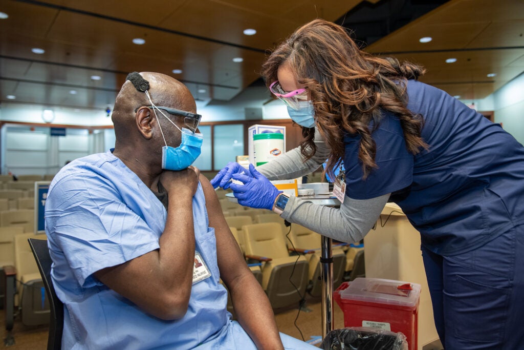 A Penn Medicine worker receives the Pfizer COVID-19 vaccine