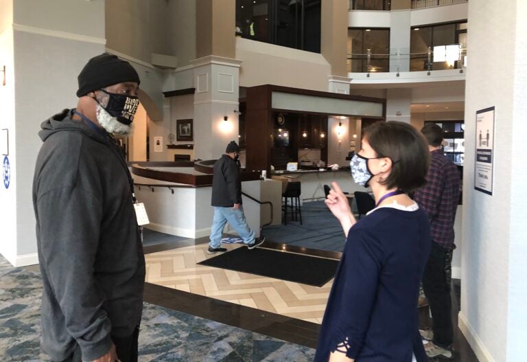 Hope Center executive director Kim Eppehimer talks to guest David Hicks in the lobby. (Cris Barrish/WHYY)