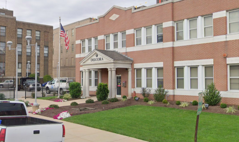 The exterior of a red-brick building is visible.