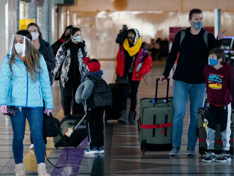 Travelers wear face masks in the main terminal of Denver International Airport