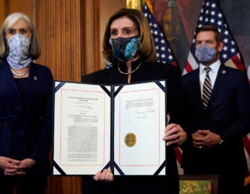 House Speaker Nancy Pelosi of Calif., displays the signed article of impeachment against President Donald Trump