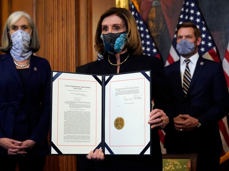 House Speaker Nancy Pelosi of Calif., displays the signed article of impeachment against President Donald Trump