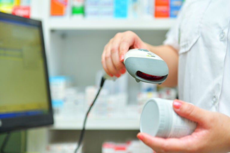 Pharmacist scanning barcode of medicine drug in a pharmacy drugstore