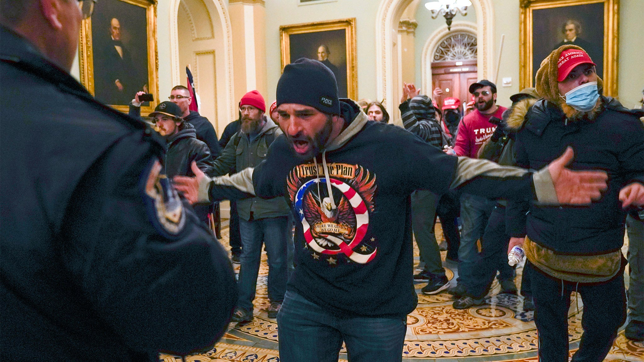 A pro-Trump insurrectionist gestures to U.S. Capitol Police in the hallway outside of the Senate chamber