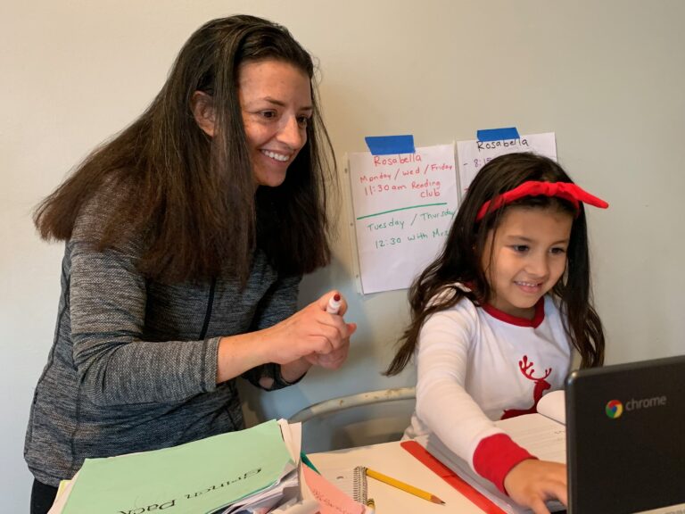 Chantelly Manzanares holds a marker while her daughter Rosabella attends class via Zoom