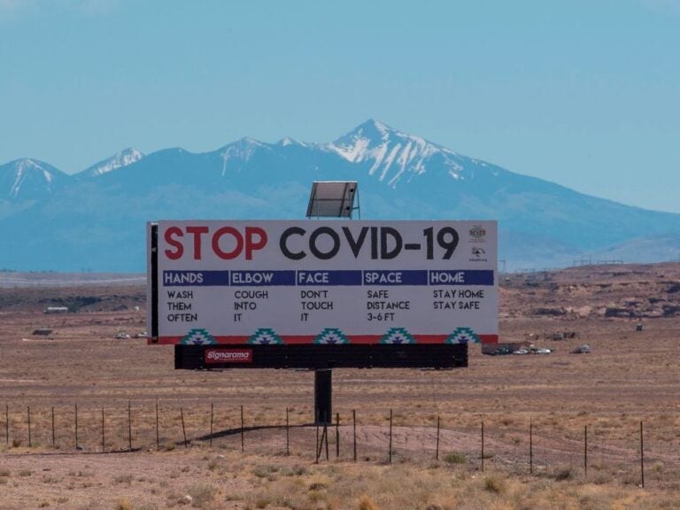 A sign warns against COVID-19 near the Navajo town of Tuba City, Ariz. As the pandemic rages across the U.S., mitigation measures continue to be critical to save lives. (Mark Ralston/AFP via Getty Images)