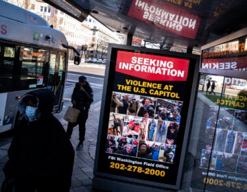At a bus stop on Pennsylvania Avenue Northwest in Washington, D.C., a notice from the FBI seeks information about people pictured during the riot at the U.S. Capitol