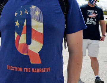 A man wears a QAnon shirt while boarding a shuttle bus in Londonderry, N.H., on Aug. 28, 2020. (Joseph Prezioso/AFP via Getty Images)