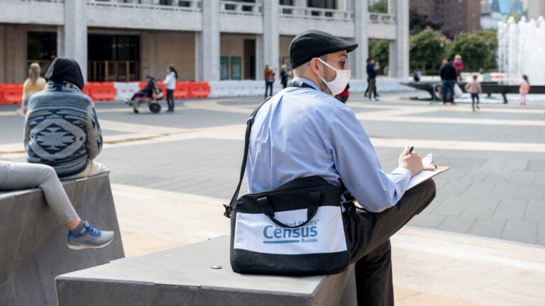 A U.S. census worker sits in the plaza of the Lincoln Center for the Performing Arts in New York City in September. The Census Bureau announced Wednesday that the first results of the 2020 census are expected to be released by April 30.