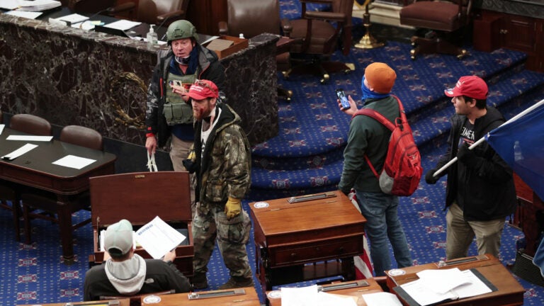 Larry Rendall Brock Jr., an Air Force veteran, is seen inside the Senate Chamber wearing a military-style helmet and tactical vest during the rioting at the U.S. Capitol. Federal prosecutors have alleged that before the attack, Brock posted on Facebook about an impending 