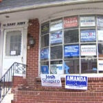 Multiple campaign signs and posters, including some supporting President Joe Biden and Vice President Kamala Harris, adorn the front window of the Montgomery County Democratic Committee’s Norristown office. (NBC10)
